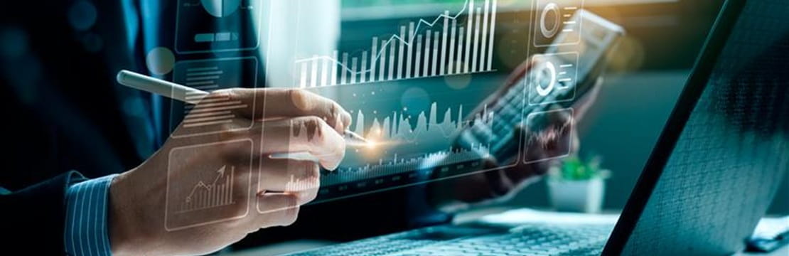 Close up of hand using phone and laptop.